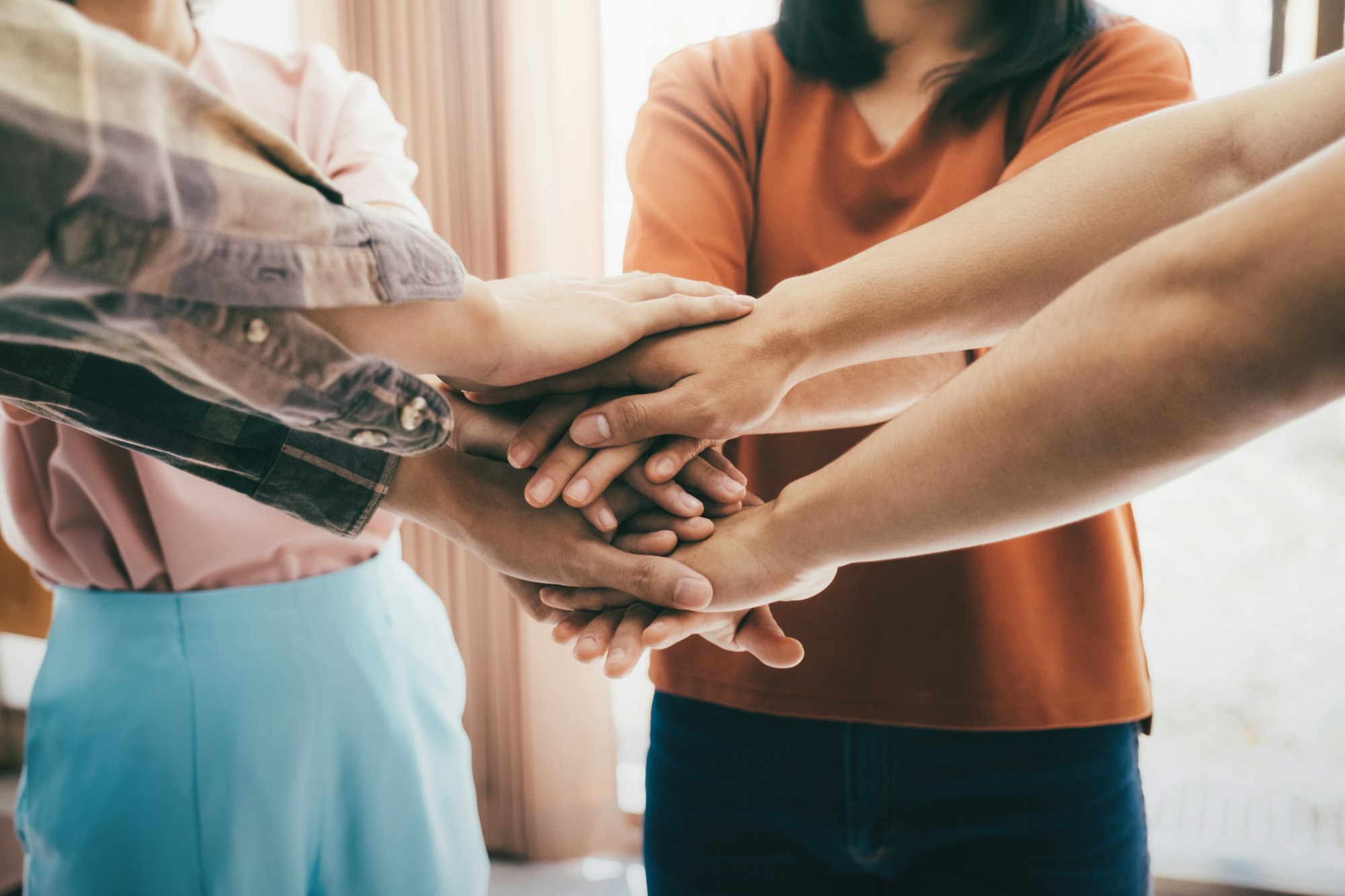 Diverse group of people holding hands in supportive gesture